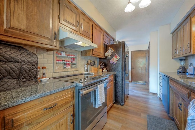 7103 Mastin St, Merriam, KS 66203 - kitchen with appliances with stainless steel finishes, under cabinet range hood, light wood-style floors, backsplash, and brown cabinets