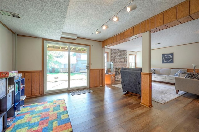 7103 Mastin St, Merriam, KS 66203 - living area featuring wainscoting, a textured ceiling, healthy amount of natural light, wood finished floors, and wooden walls