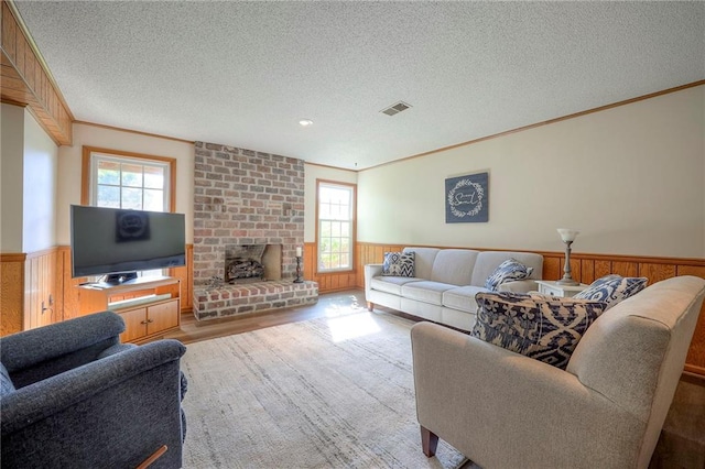 7103 Mastin St, Merriam, KS 66203 - living area with a textured ceiling, wainscoting, ornamental molding, wood finished floors, and a brick fireplace