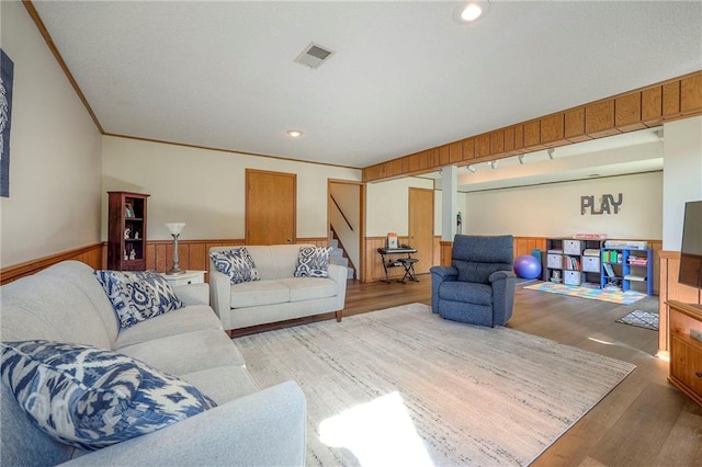 7103 Mastin St, Merriam, KS 66203 - living area with wainscoting, wood finished floors, stairway, ornamental molding, and recessed lighting