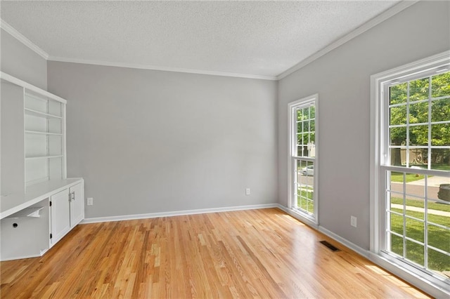 15614 Outlook St, Overland Park, KS 66223 - empty room with plenty of natural light, a textured ceiling, light wood-style flooring, and ornamental molding