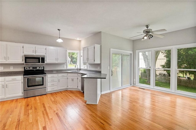 15614 Outlook St, Overland Park, KS 66223 - kitchen featuring appliances with stainless steel finishes, dark countertops, and white cabinetry