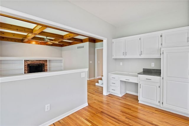 15614 Outlook St, Overland Park, KS 66223 - kitchen with ceiling fan, built in desk, white cabinetry, coffered ceiling, and light wood-style flooring