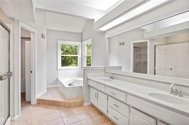 15614 Outlook St, Overland Park, KS 66223 - full bath featuring a walk in closet, tile patterned flooring, double vanity, a stall shower, and a textured ceiling