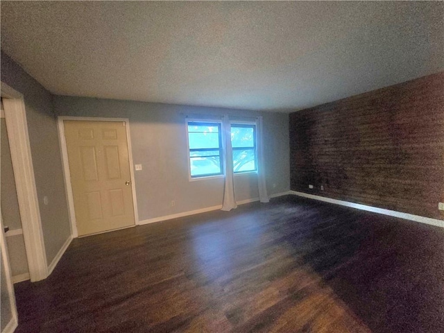 408 Creach St, Warrensburg, MO 64093 - empty room with dark wood-type flooring and a textured ceiling