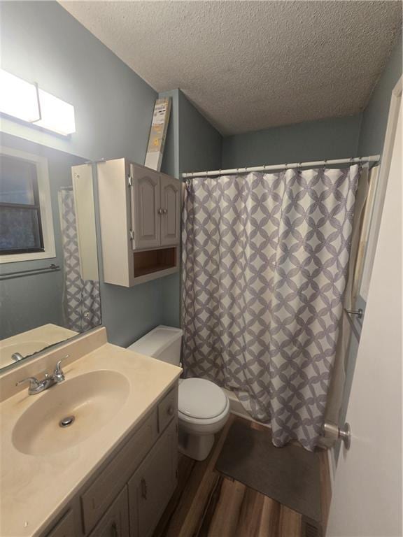 408 Creach St, Warrensburg, MO 64093 - bathroom with a textured ceiling, vanity, wood finished floors, and curtained shower