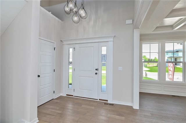 6126 Lewis Dr, Shawnee, KS 66226 - entryway with wood finished floors, a towering ceiling, a chandelier, and crown molding
