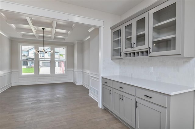 6126 Lewis Dr, Shawnee, KS 66226 - kitchen featuring gray cabinetry, a chandelier, coffered ceiling, ornamental molding, and glass insert cabinets
