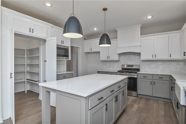 6126 Lewis Dr, Shawnee, KS 66226 - kitchen with stainless steel appliances, gray cabinets, wood finished floors, a center island, and decorative backsplash