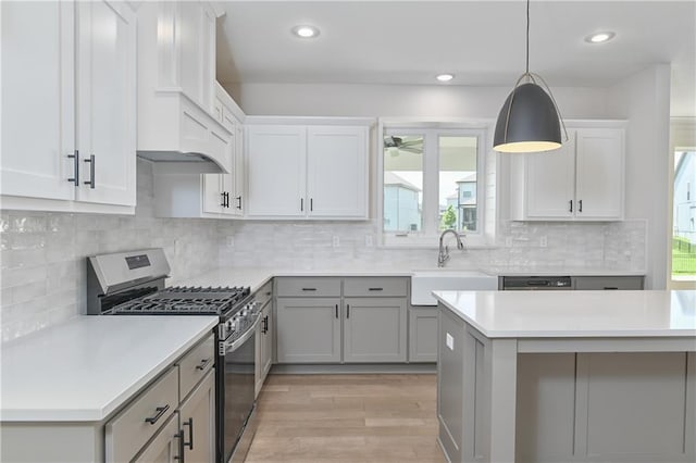 6126 Lewis Dr, Shawnee, KS 66226 - kitchen featuring stainless steel appliances, light countertops, light wood-type flooring, decorative light fixtures, and gray cabinetry