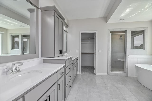 6126 Lewis Dr, Shawnee, KS 66226 - bathroom featuring a stall shower, a soaking tub, vanity, a walk in closet, and tile patterned floors