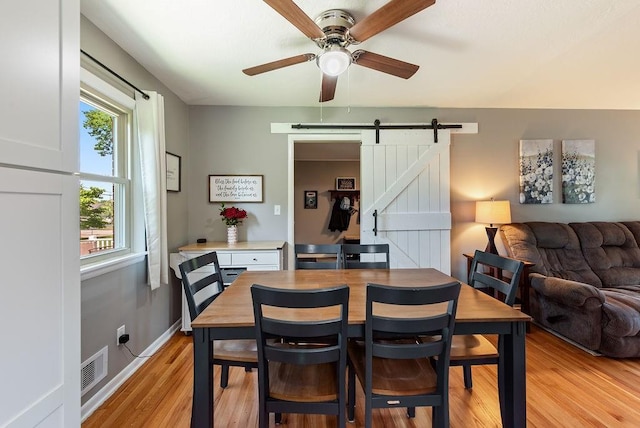 14224 E 36th St, Independence, MO 64055 - dining room with a barn door, a ceiling fan, and light wood-type flooring