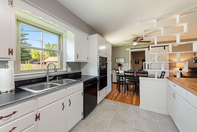 14224 E 36th St, Independence, MO 64055 - kitchen featuring dishwasher, light tile patterned floors, ceiling fan, white cabinets, and dark countertops