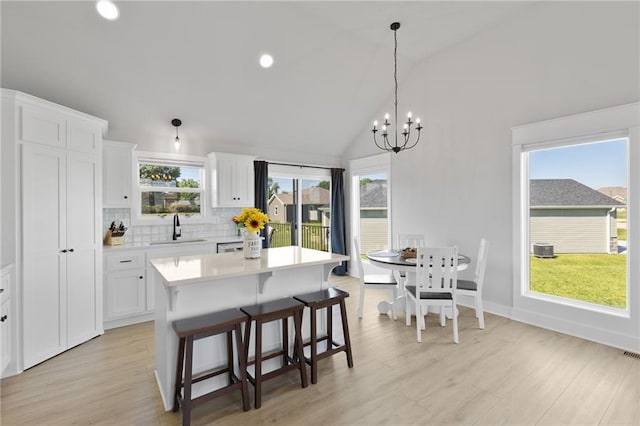 462 SE 90th Rd, Warrensburg, MO 64093 - kitchen featuring light countertops, white cabinets, a chandelier, a breakfast bar, and a kitchen island