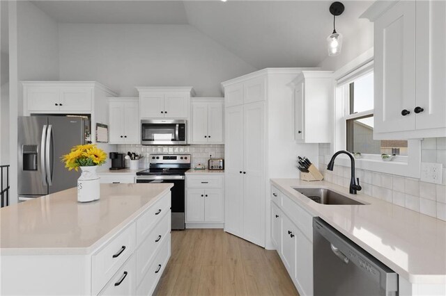 462 SE 90th Rd, Warrensburg, MO 64093 - kitchen with stainless steel appliances, vaulted ceiling, backsplash, light countertops, and white cabinetry