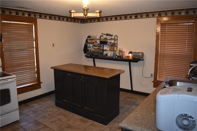 21570 Mclouth Rd, Mc Louth, KS 66054 - laundry room with light tile patterned floors and a textured ceiling