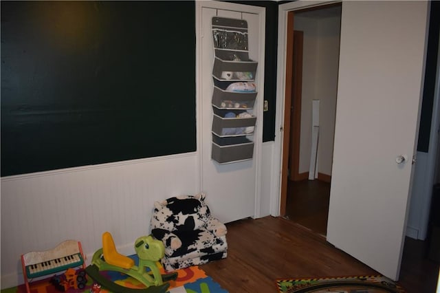 21570 Mclouth Rd, Mc Louth, KS 66054 - recreation room featuring dark wood-style flooring and a wainscoted wall
