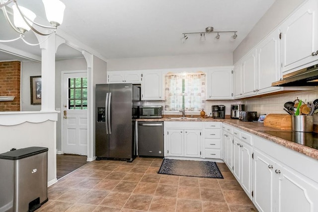 6305 N Bales Ave, Gladstone, MO 64119 - kitchen with stainless steel appliances, white cabinetry, under cabinet range hood, and backsplash