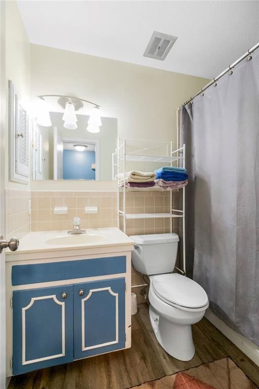 6305 N Bales Ave, Gladstone, MO 64119 - bathroom featuring wood finished floors, vanity, and tile walls