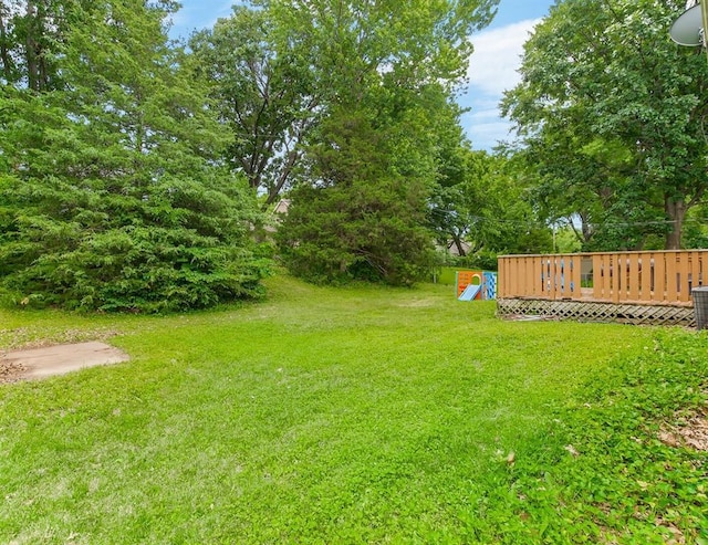 6305 N Bales Ave, Gladstone, MO 64119 - view of green lawn with a wooden deck and view of wooded area