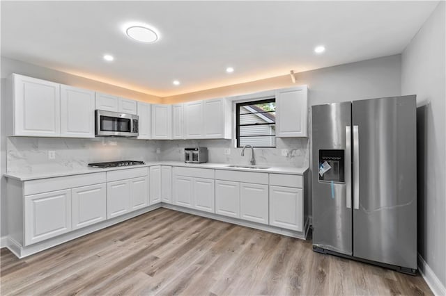 10312 W 48th Ter, Shawnee, KS 66203 - kitchen featuring appliances with stainless steel finishes, light wood-style flooring, decorative backsplash, and recessed lighting