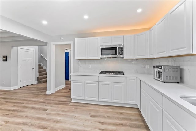 10312 W 48th Ter, Shawnee, KS 66203 - kitchen featuring stainless steel microwave, light countertops, white cabinetry, recessed lighting, and tasteful backsplash