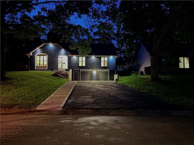 10312 W 48th Ter, Shawnee, KS 66203 - view of front of home with an attached garage, asphalt driveway, and a yard