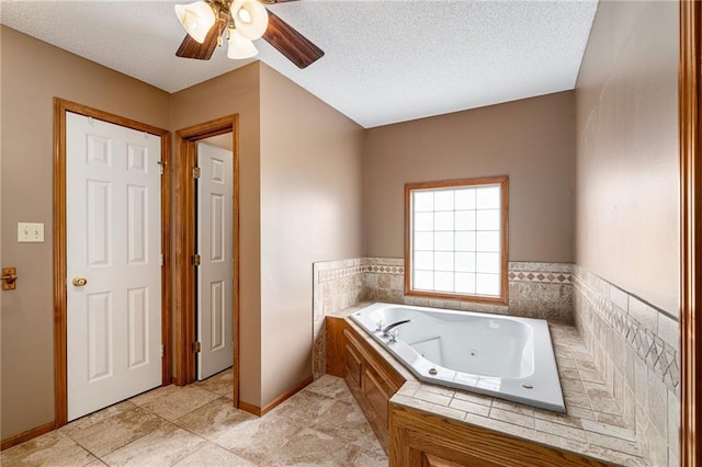 18807 E 34th St, Independence, MO 64057 - full bathroom with a jetted tub, a ceiling fan, a textured ceiling, and tile patterned flooring