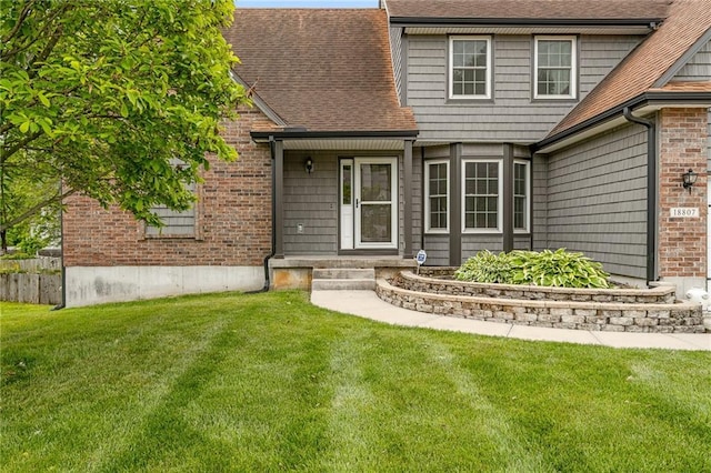 18807 E 34th St, Independence, MO 64057 - property entrance with a yard, a shingled roof, and brick siding