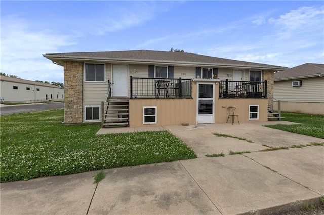 301-A N 3rd St, Odessa, MO 64076 - rear view of property featuring stairway, a lawn, a wall unit AC, and stone siding
