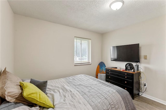 301-A N 3rd St, Odessa, MO 64076 - bedroom featuring wood finished floors and a textured ceiling