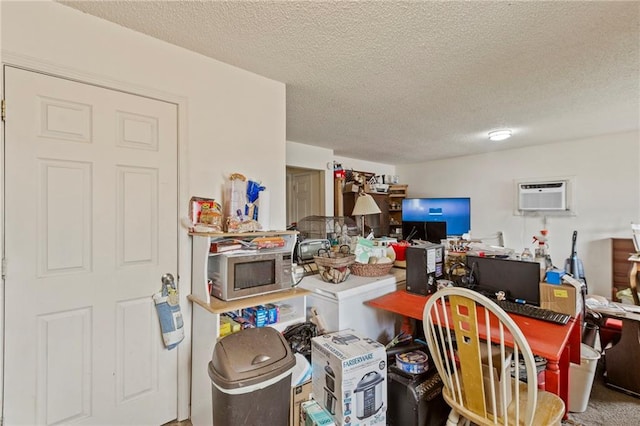 301-A N 3rd St, Odessa, MO 64076 - interior space featuring stainless steel microwave, an AC wall unit, a textured ceiling, and a desk