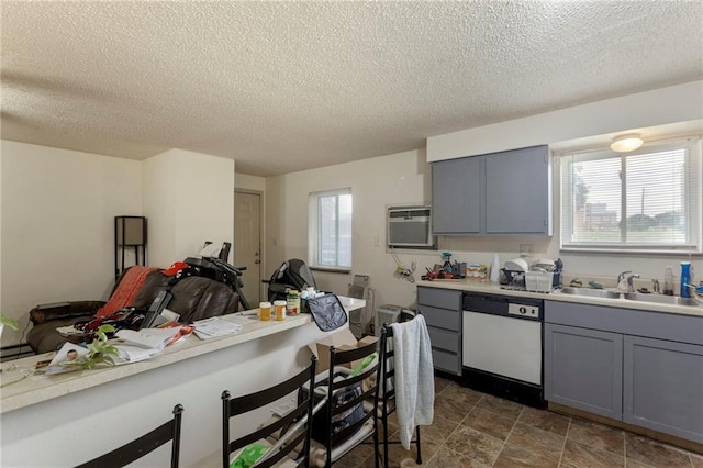 301-A N 3rd St, Odessa, MO 64076 - kitchen featuring dishwasher, gray cabinets, light countertops, a textured ceiling, and a breakfast bar