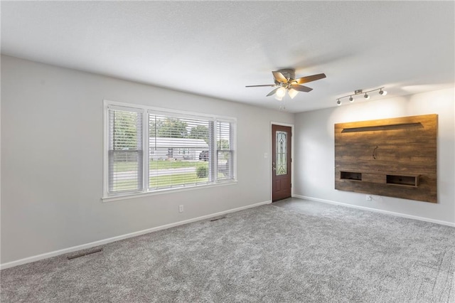 801 NE 67th Ter, Gladstone, MO 64118 - unfurnished living room with a ceiling fan, carpet, and track lighting