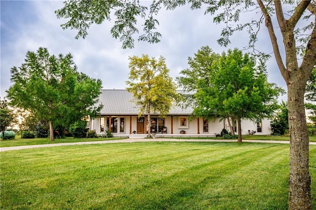 3247 Oregon Rd, Ottawa, KS 66067 - ranch-style house featuring a front yard, covered porch, and a metal roof