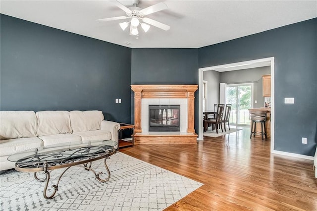 18300 Oak St, Gardner, KS 66030 - living room with wood finished floors, a ceiling fan, and a tiled fireplace
