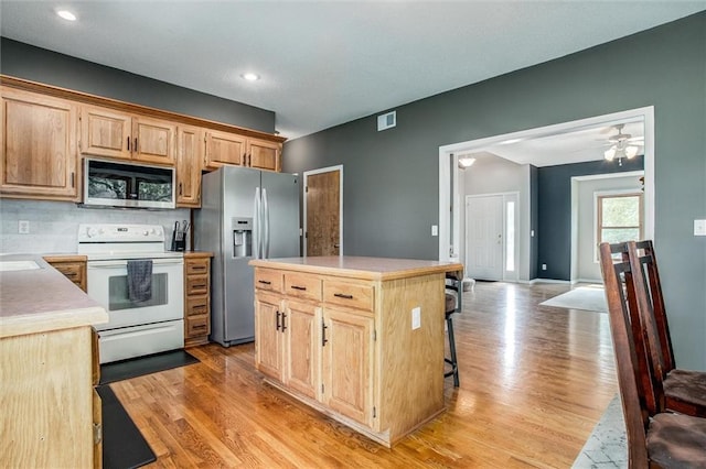18300 Oak St, Gardner, KS 66030 - kitchen featuring stainless steel appliances, light brown cabinetry, light wood-type flooring, and recessed lighting