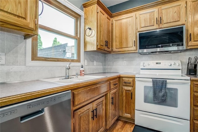 18300 Oak St, Gardner, KS 66030 - kitchen featuring stainless steel appliances, tasteful backsplash, light countertops, and wood finished floors