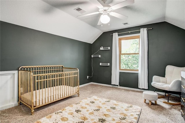 18300 Oak St, Gardner, KS 66030 - carpeted bedroom featuring lofted ceiling, a crib, ceiling fan, and a textured ceiling