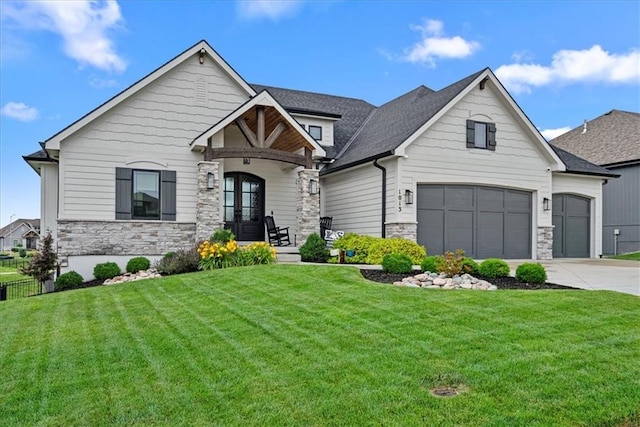 1013 Old Hickory Rd, Greenwood, MO 64034 - view of front of house featuring stone siding, a front yard, concrete driveway, an attached garage, and roof with shingles
