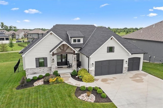 1013 Old Hickory Rd, Greenwood, MO 64034 - view of front of home featuring french doors, stone siding, a front lawn, concrete driveway, and a shingled roof