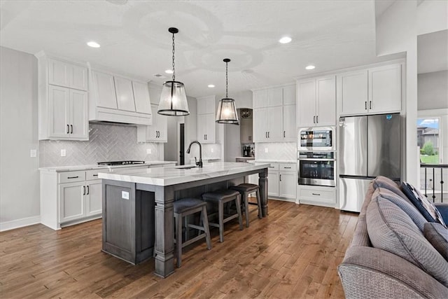 1013 Old Hickory Rd, Greenwood, MO 64034 - kitchen featuring stainless steel appliances, white cabinetry, a breakfast bar, open floor plan, and recessed lighting