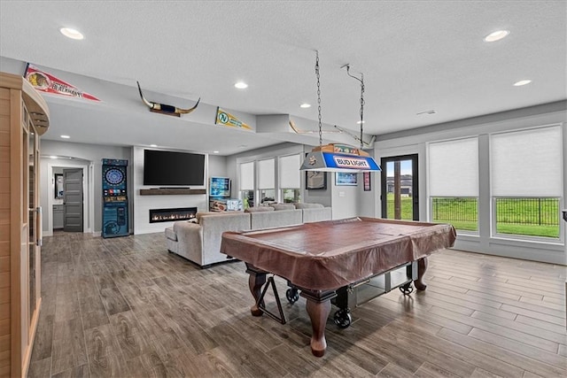 1013 Old Hickory Rd, Greenwood, MO 64034 - rec room featuring wood finished floors, a textured ceiling, pool table, a glass covered fireplace, and recessed lighting