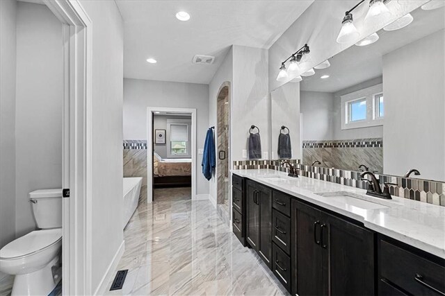1013 Old Hickory Rd, Greenwood, MO 64034 - ensuite bathroom featuring double vanity, marble tiled flooring, a tub to relax in, recessed lighting, and backsplash