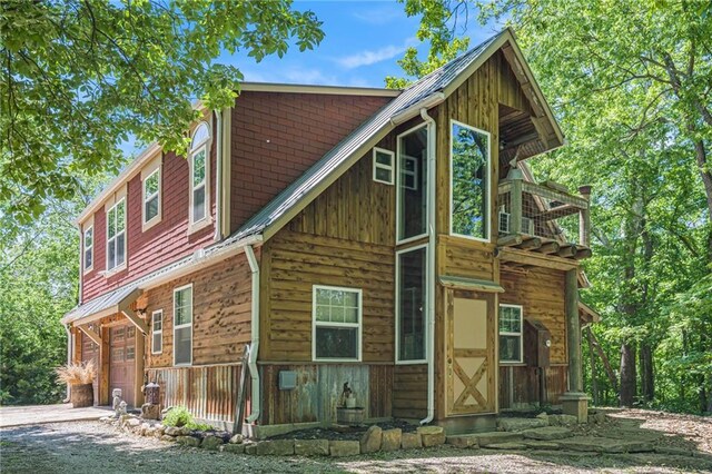 15335 Hh Hwy, Platte City, MO 64079 - view of front of home featuring dirt driveway, an attached garage, and a balcony
