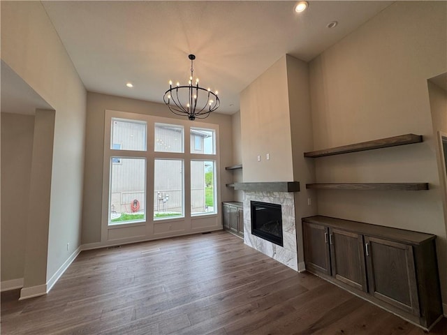 11494 S Longview Rd, Olathe, KS 66061 - unfurnished living room with a glass covered fireplace, dark wood-style floors, a chandelier, and recessed lighting