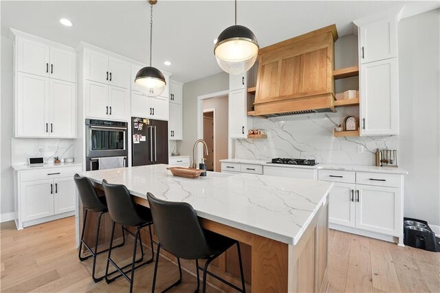 8422 NE 147th St, Liberty, MO 64068 - kitchen with open shelves, stainless steel appliances, a kitchen island with sink, light wood-type flooring, and recessed lighting