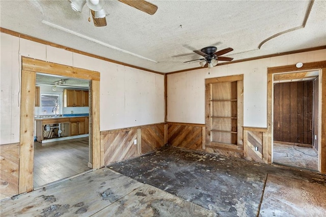 715 Walnut Ave, Osawatomie, KS 66064 - spare room with a ceiling fan, wooden walls, and a textured ceiling