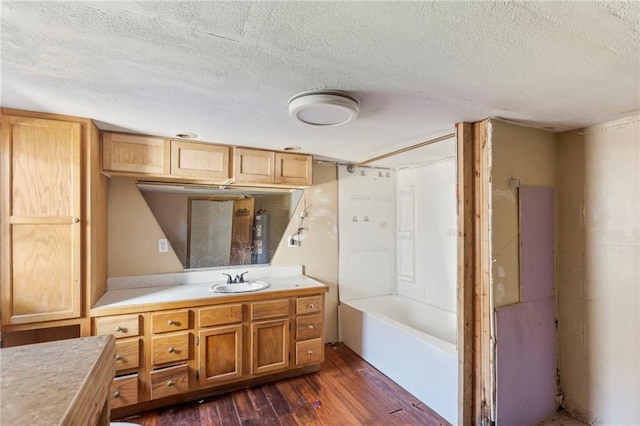 715 Walnut Ave, Osawatomie, KS 66064 - full bath with vanity, a textured ceiling, and wood finished floors