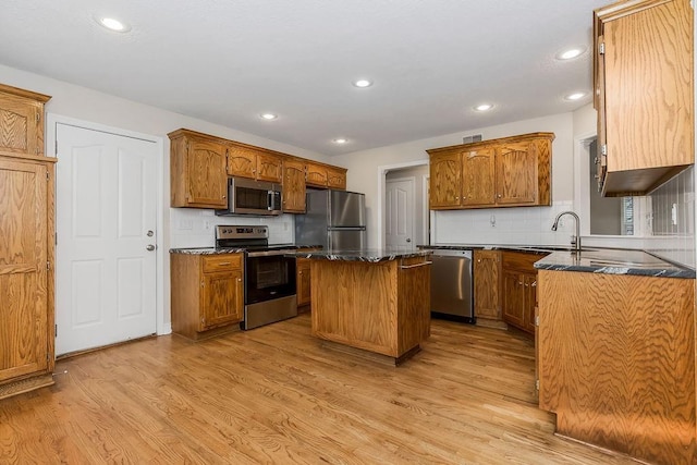 1129 SW Georgetown Dr, Lees Summit, MO 64082 - kitchen with appliances with stainless steel finishes, a center island, light wood-style floors, recessed lighting, and backsplash